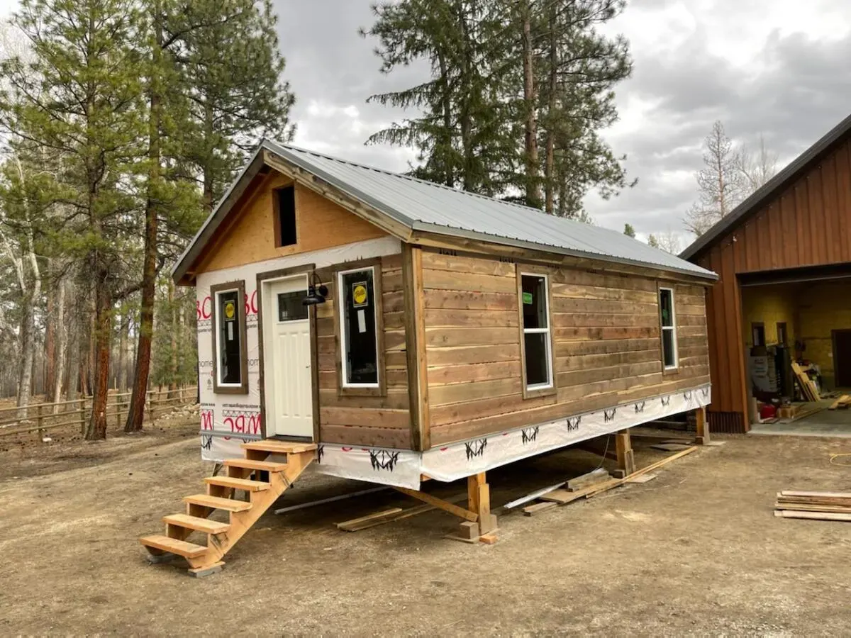 Small cabin entry framed by natural wood siding and trim
